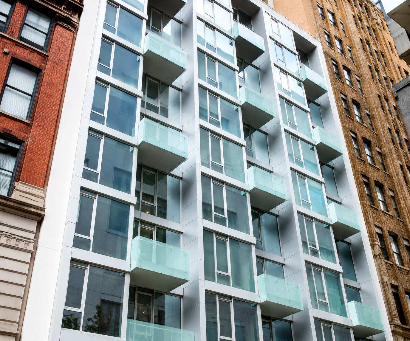 Modern apartment building with glass balconies and contemporary architecture.