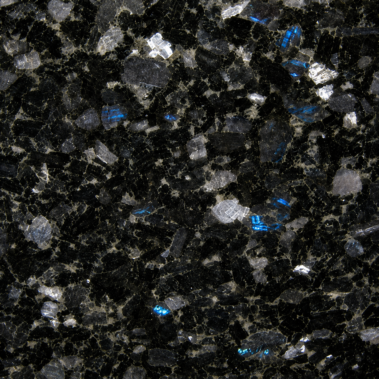 Close-up of black granite with blue iridescent mineral flecks.