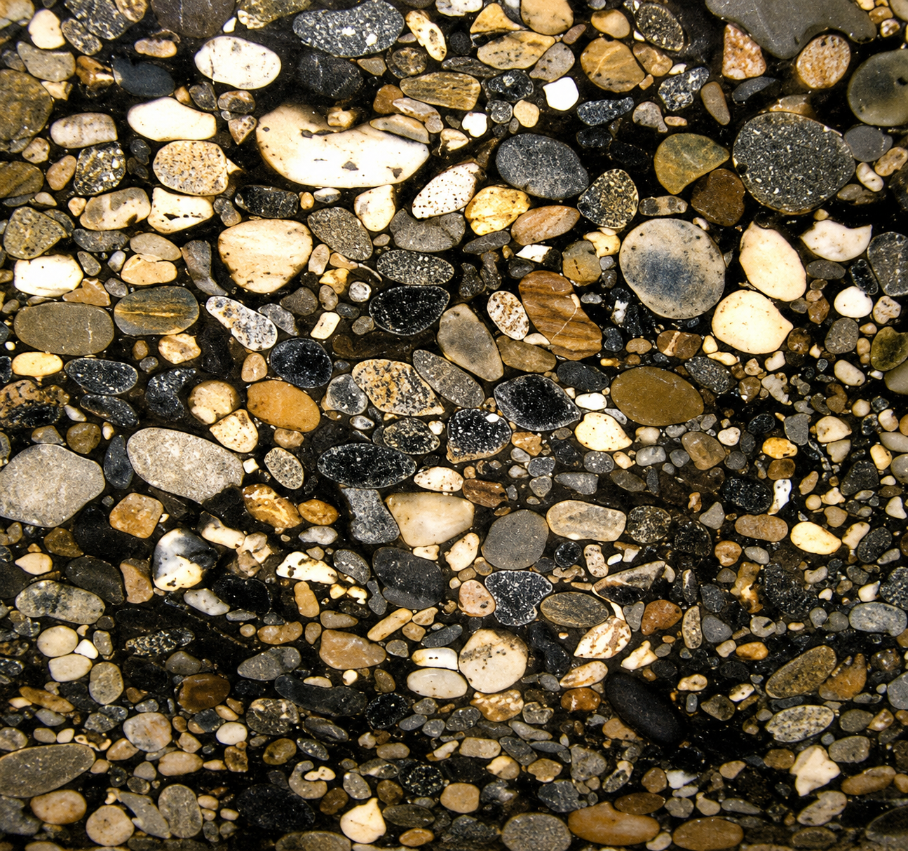 Close-up of pebble-style quartz with mixed earth-tone stones in a polished finish.